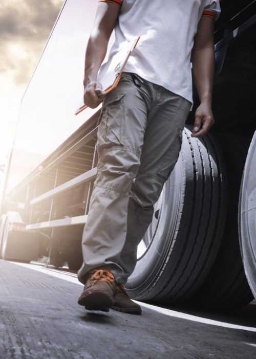 Truck Driver Walking and Checking A Truck Wheels and Tires. Inspection Maintenance and Safety forTruck Driving. Truck Driver Walking and Checking A Truck Wheels and Tires. Inspection Maintenance and Safety forTruck Driving.